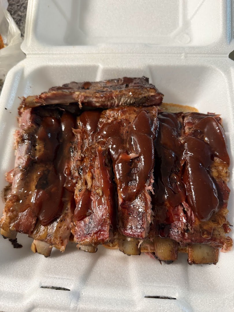 Pulled pork and sides on paper plates.